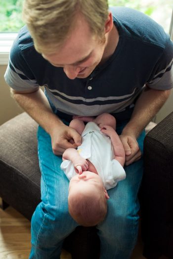 Dad smiles at the baby in his lap