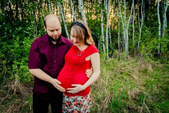 Couples maternity photos in a forest at sunset