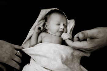 Dad holds the hand of his baby daughter